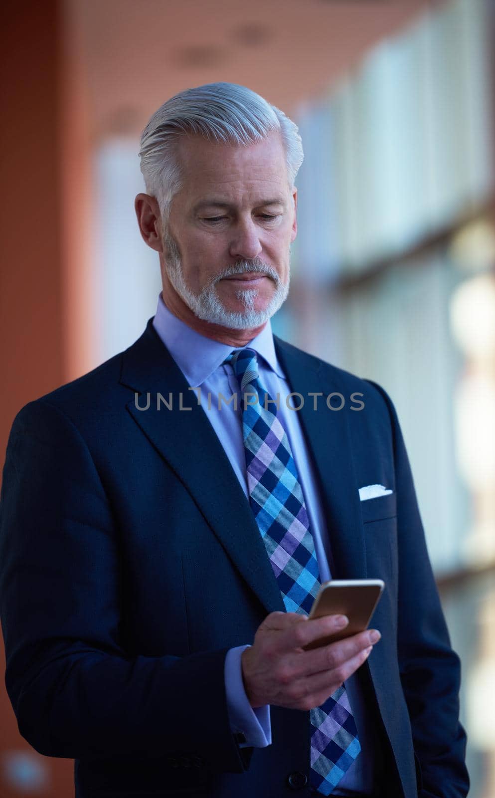 senior business man talk on mobile phone  at modern bright office interior