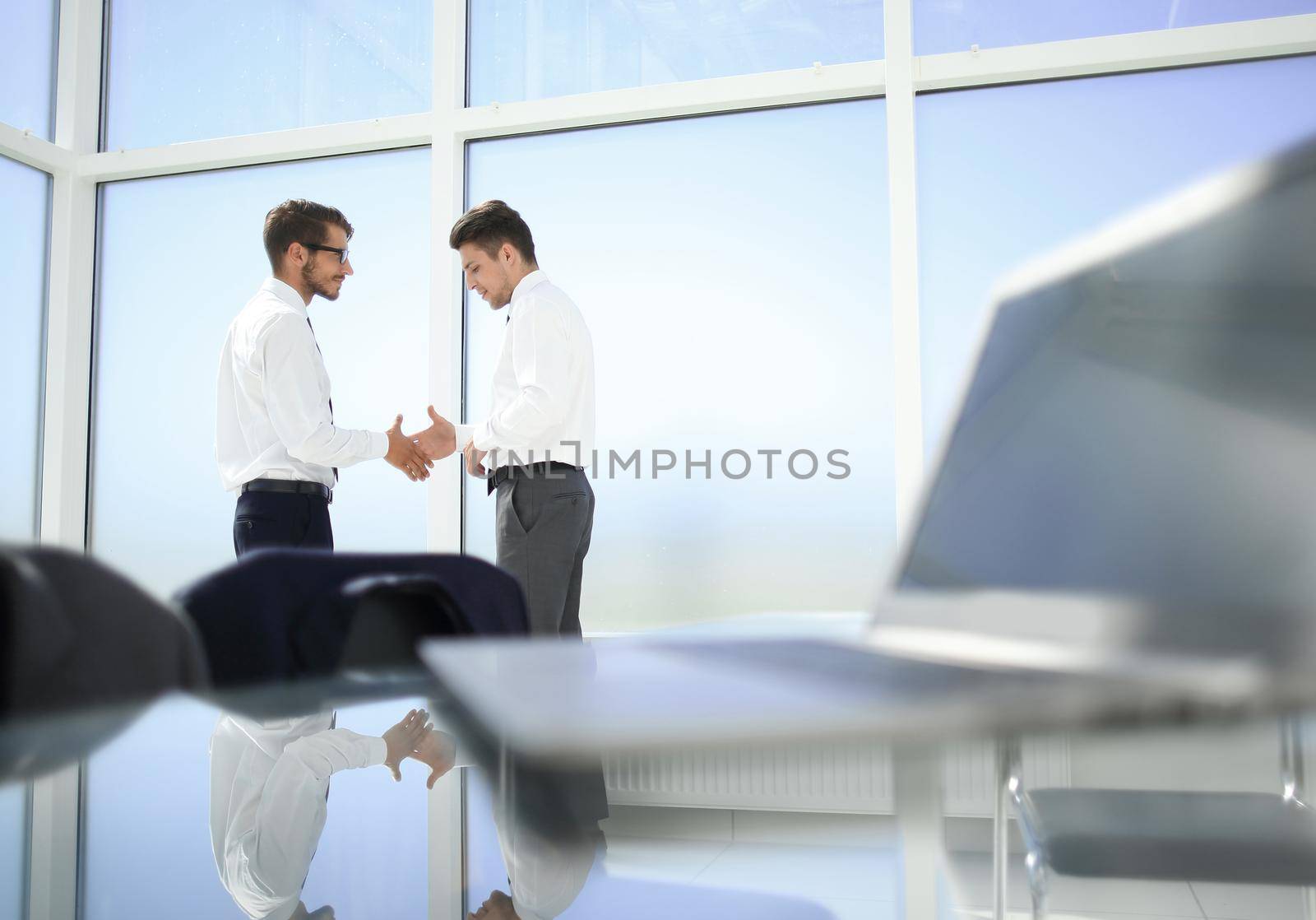 Business meeting at the table shaking hands conclusion of the contract