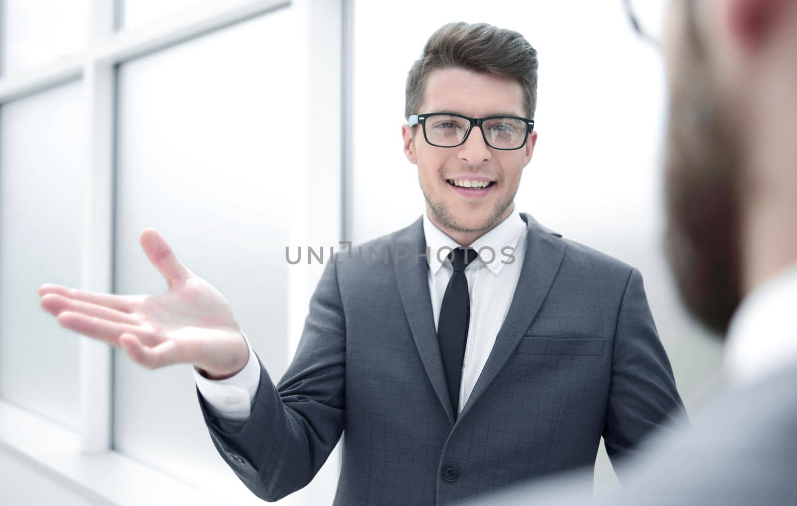young businessman talking standing in the office by asdf
