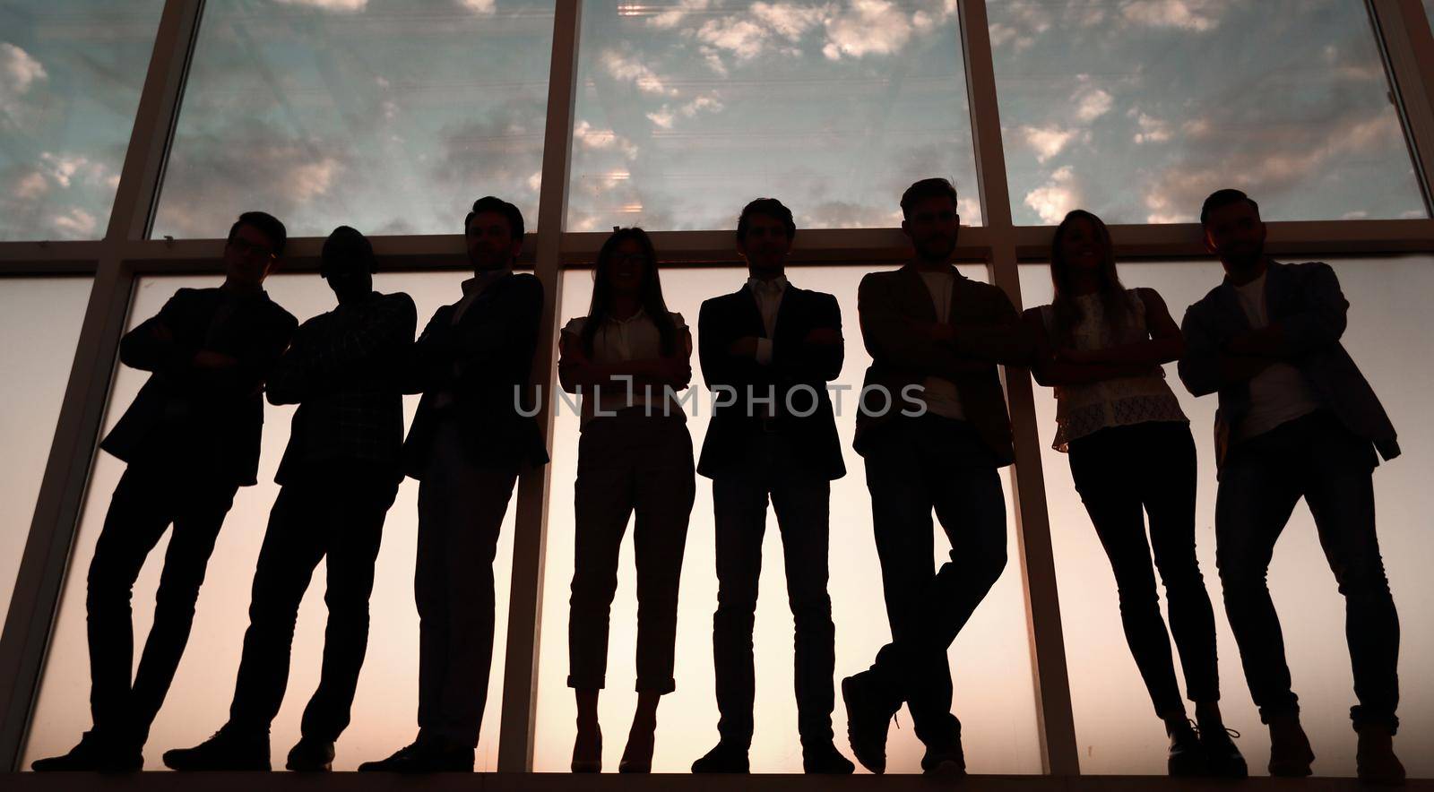 silhouette of a group of business people standing near the office window by asdf