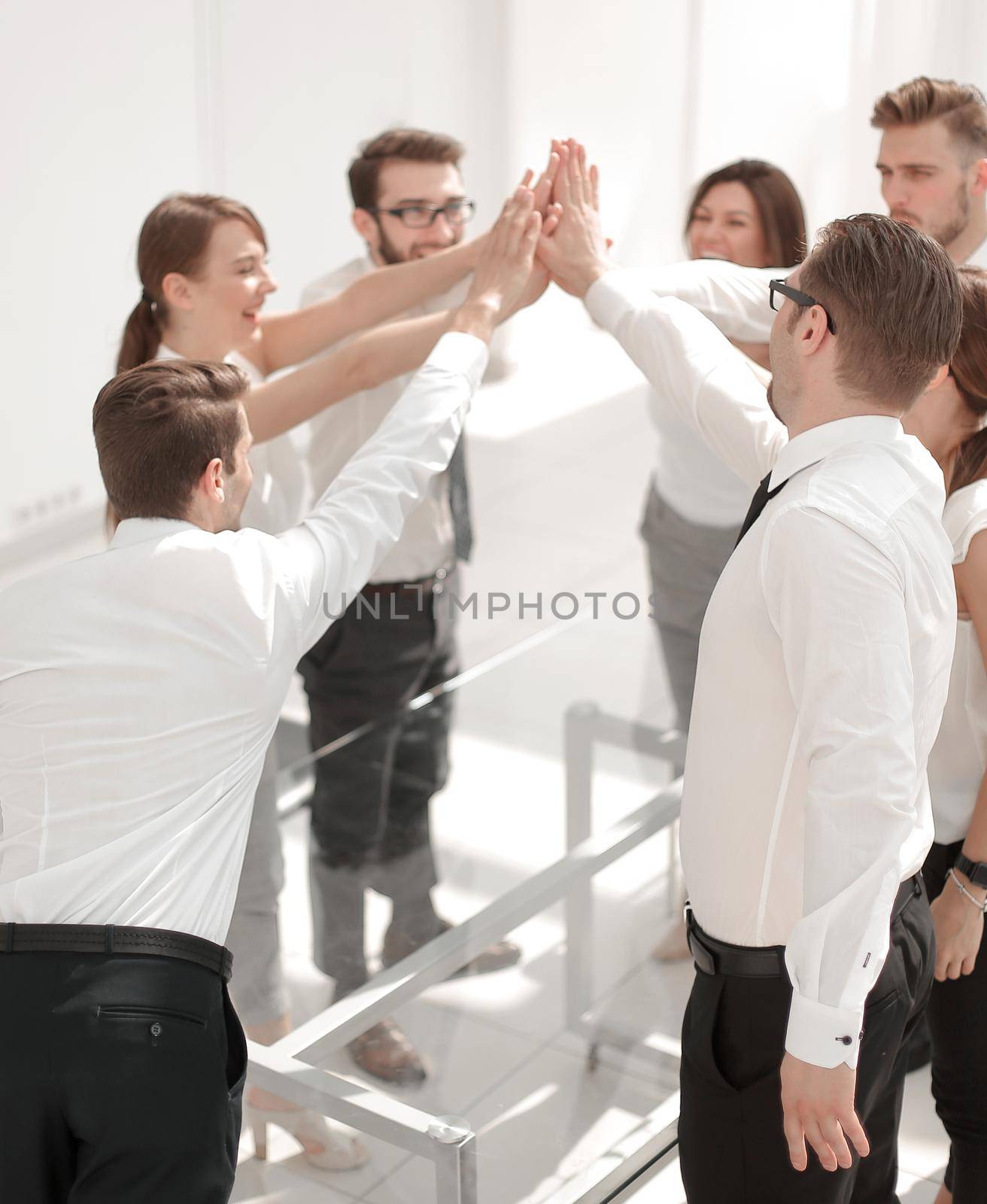 successful business teams make a high five over their Desk by asdf