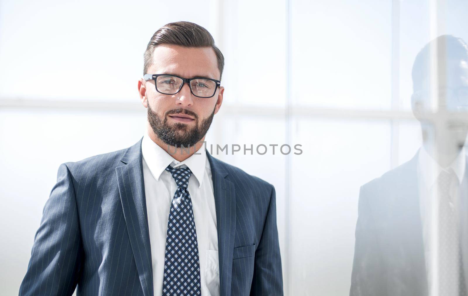 confident businessman on background of office window.photo with copy space