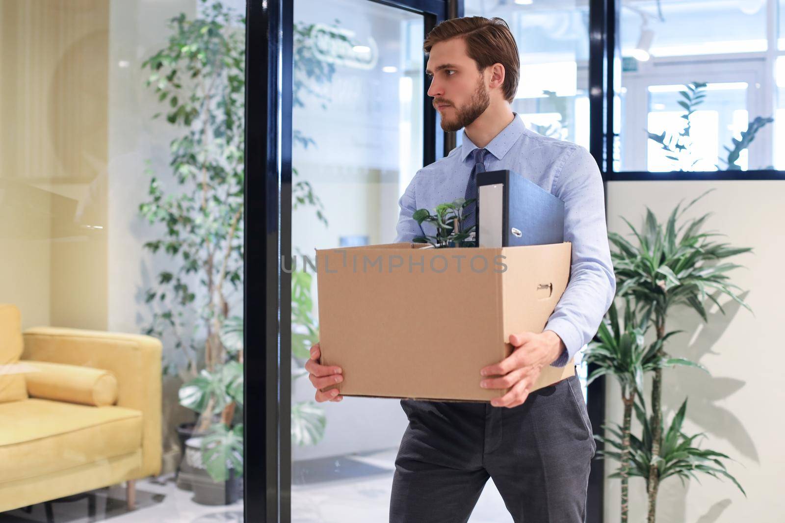 Dismissed worker going from the office with his office supplies