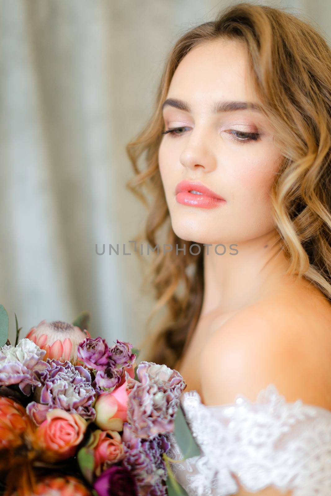 Close up portrait of gorgeous bride with bouquet of flowers at studio. Concept of floristic art, beauty and beautiful wedding photo session.