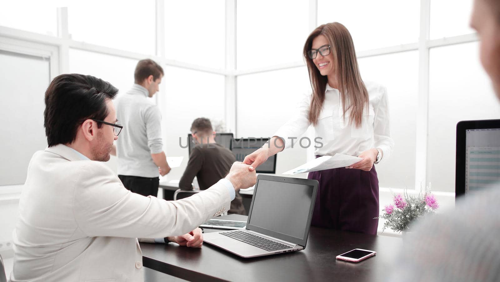 handshake employees over the Desk in the office .office weekdays