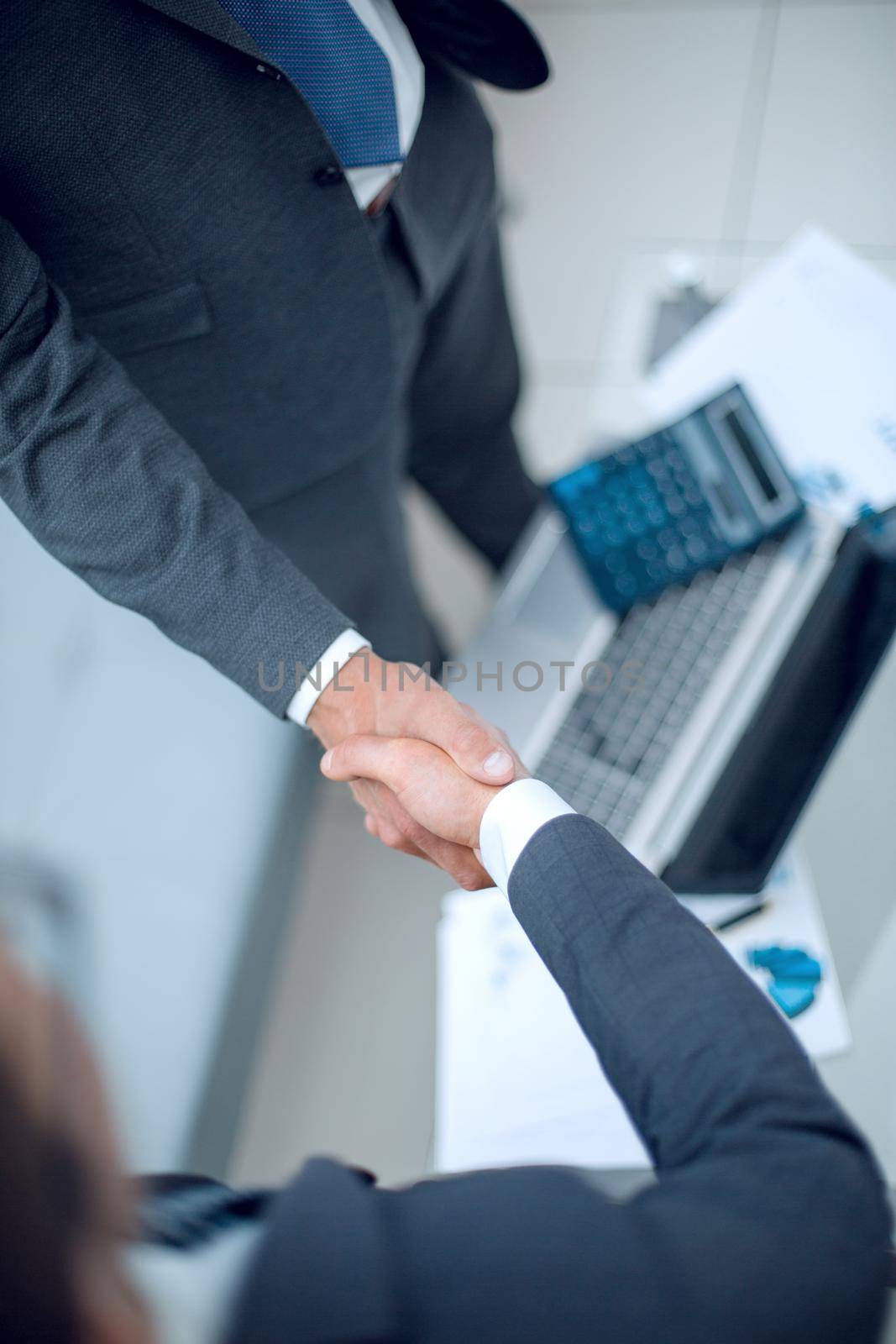 close up.handshake trading partners over the desktop by asdf