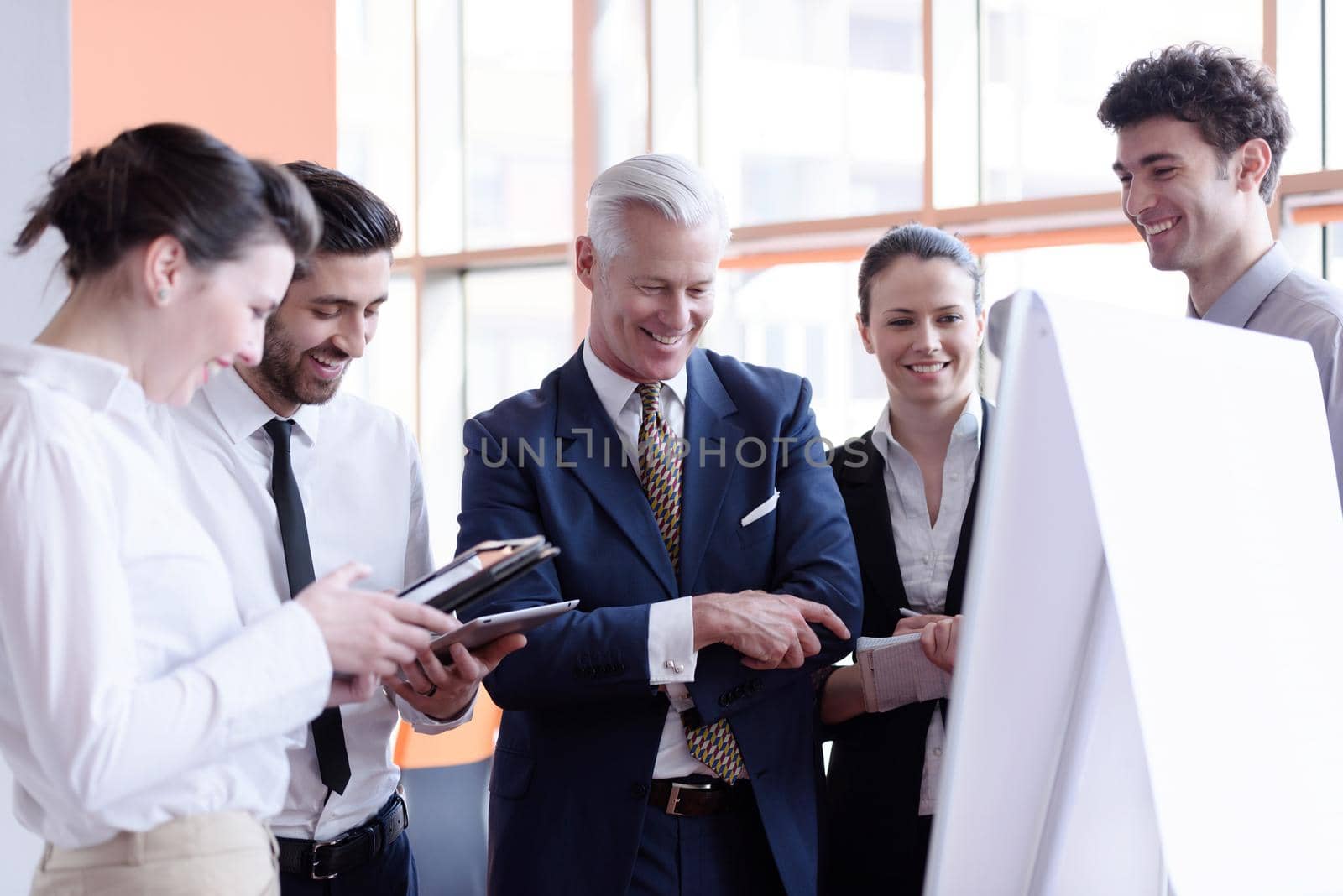 young startup businessman making presentation of project to senior investior, group of business people taking notes and make plans on white  flip board and tablet computer