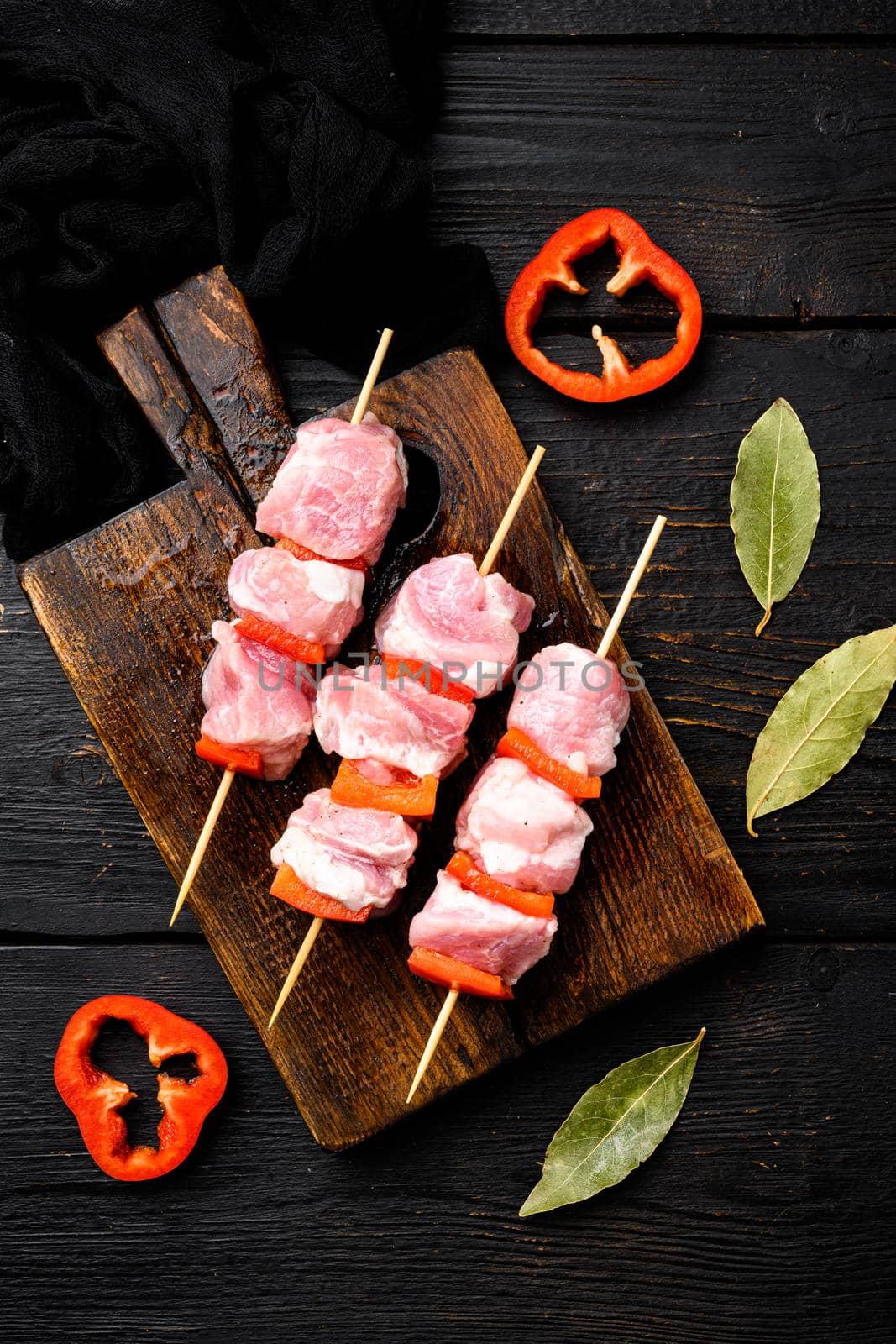 Raw shish kebab. Barbecue Meat Spices and Herbs set, top view flat lay, on black wooden table background