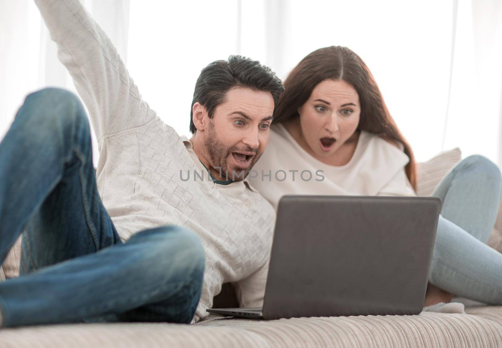 young couple watching TV show on their laptop by asdf