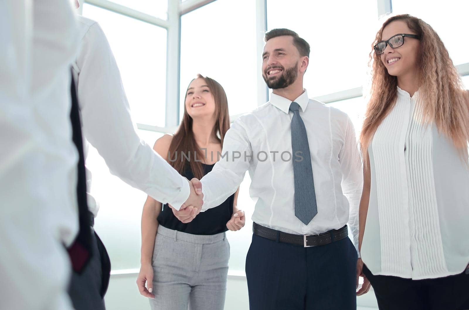 business people shake hands standing in the office by asdf