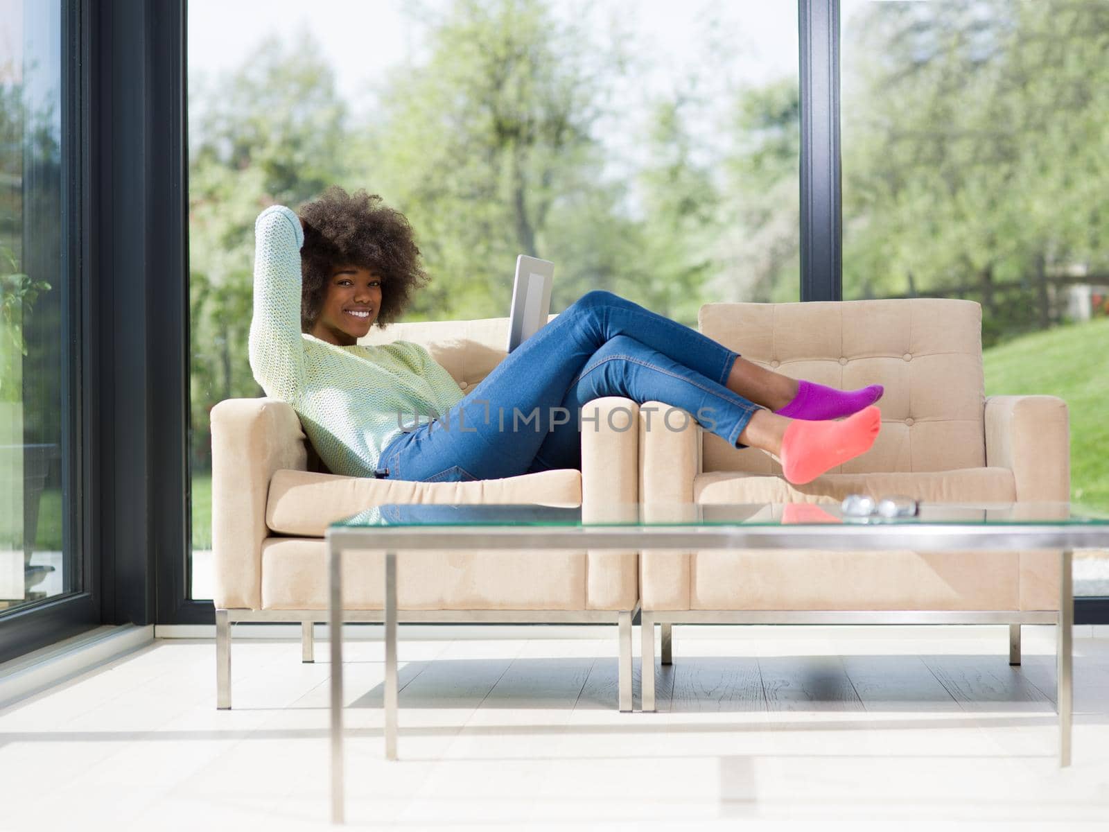 young african american woman at home using digital tablet by dotshock