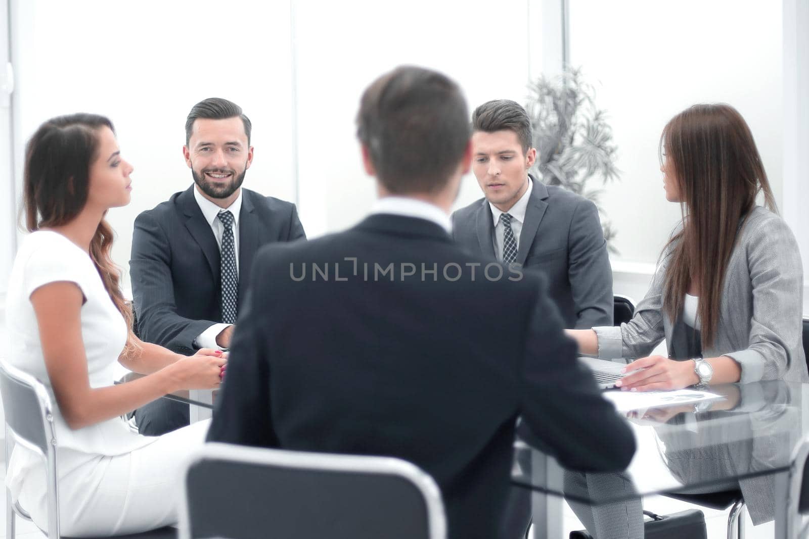 group of business people sitting at a table at an office working meeting by asdf