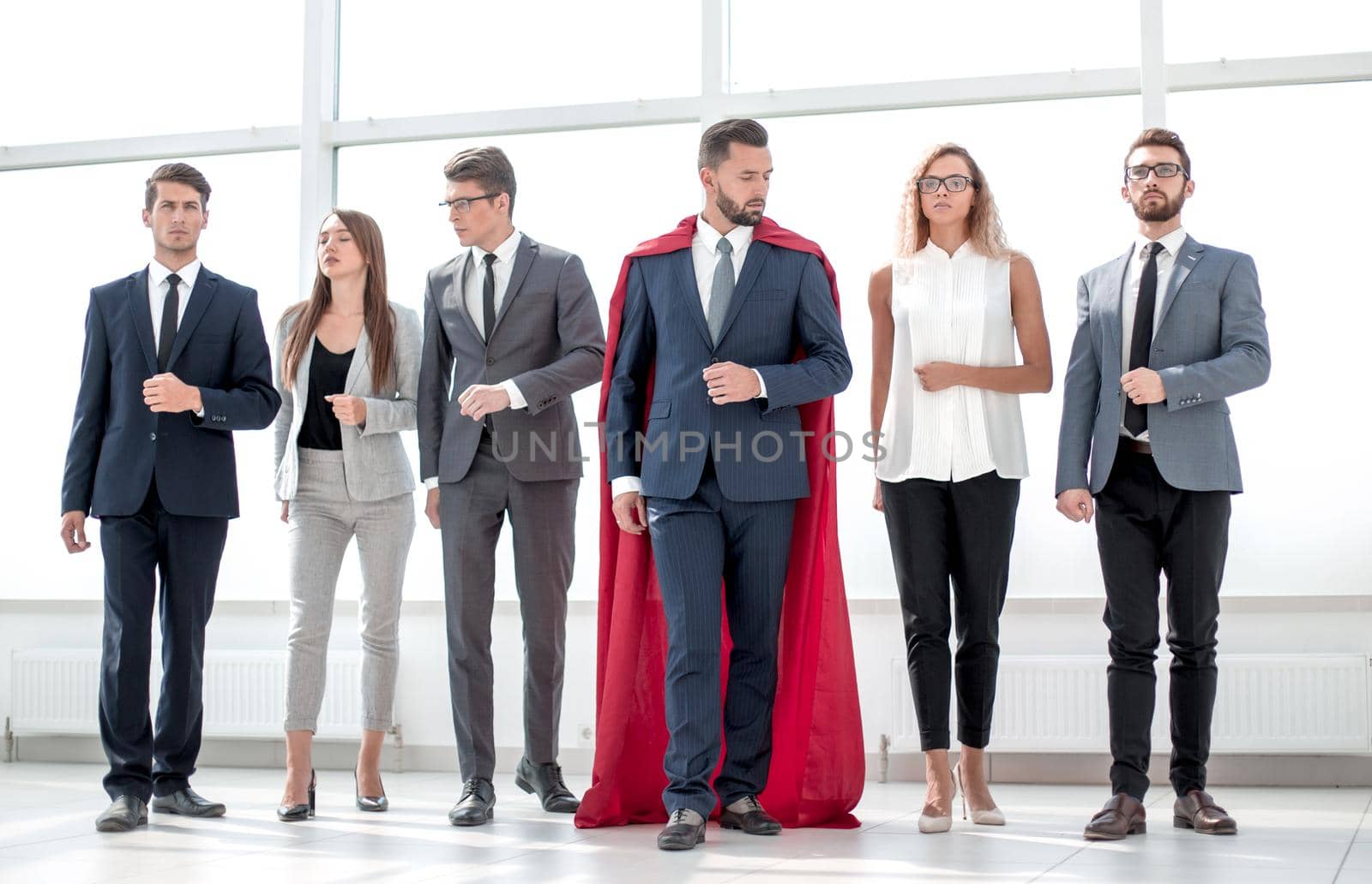 businessman in a red superhero cloak and his business team by asdf