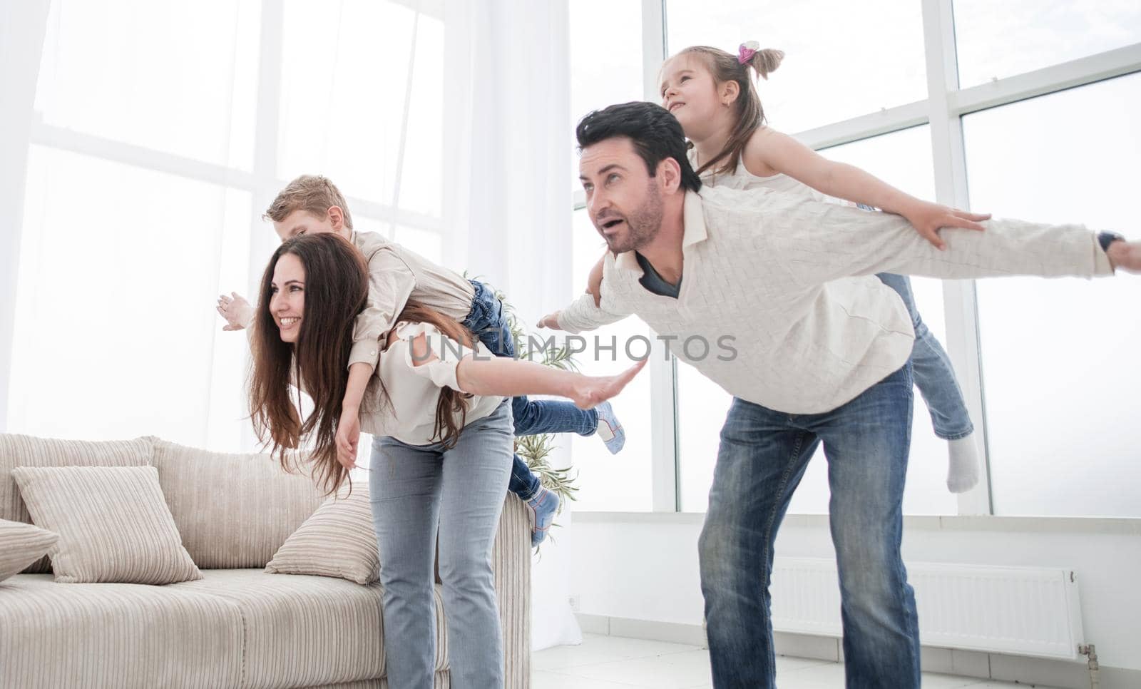 happy parents play with children at home. by asdf