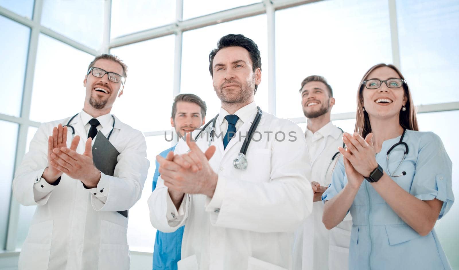 Portrait of medical team applauding and smiling in meeting at conference room