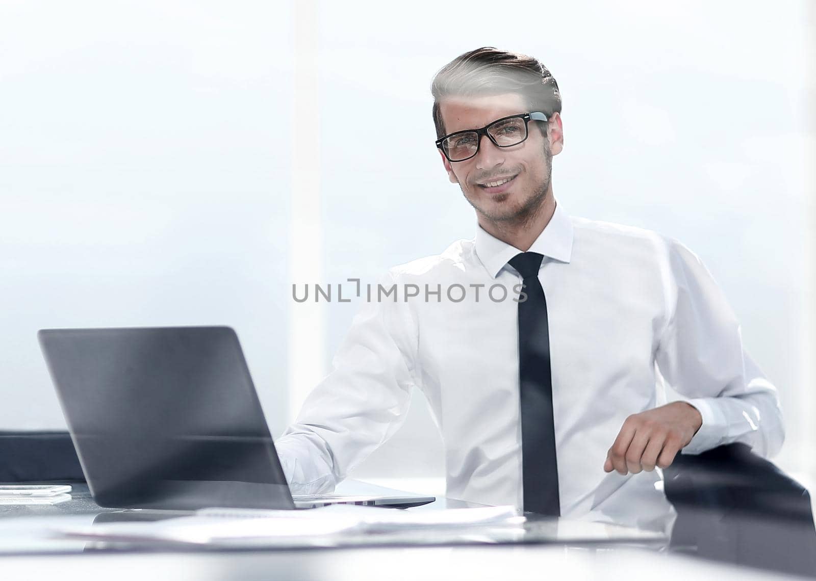 smiling young businessman sitting in a spacious office.photo with copy space