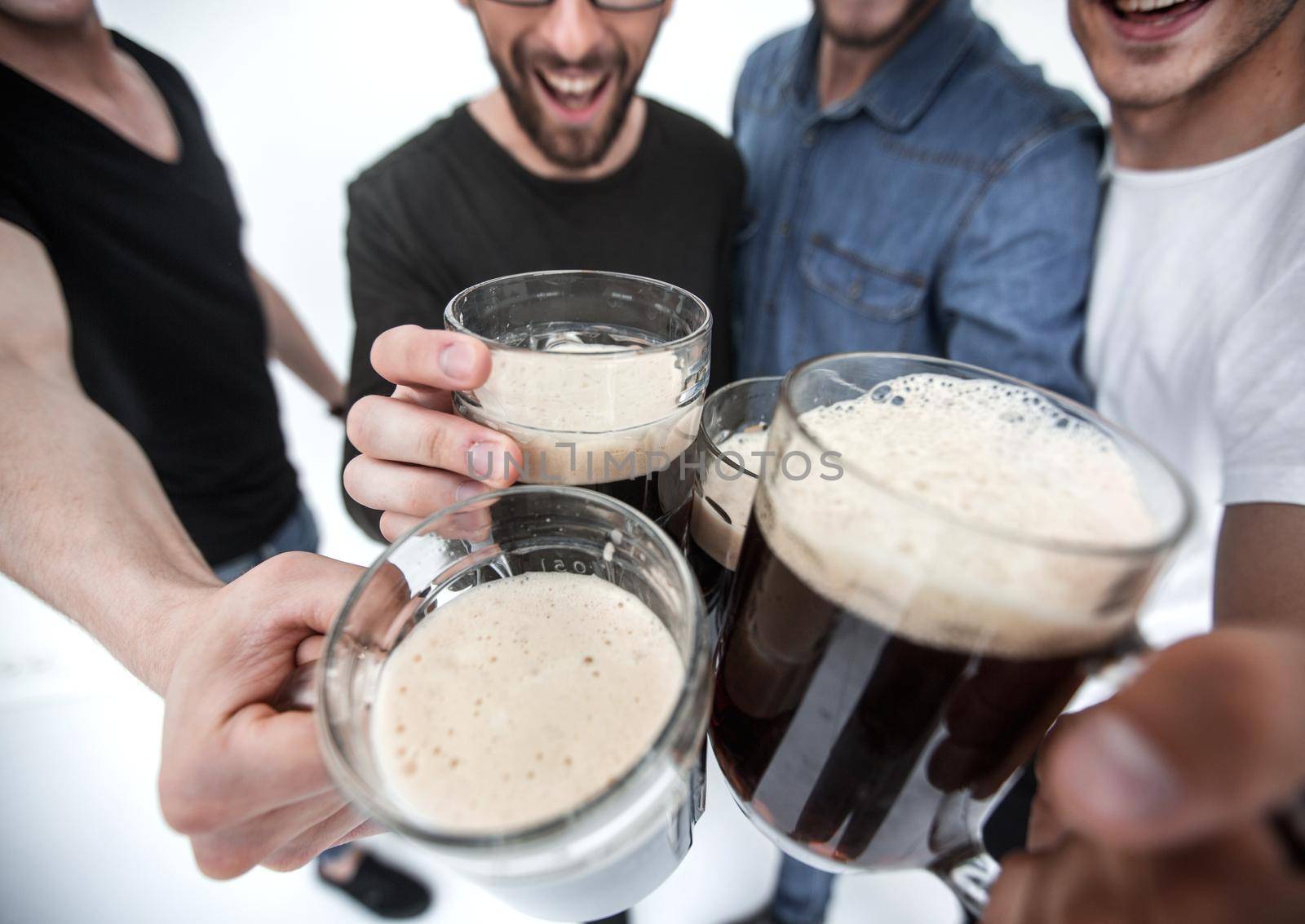 close up.mugs of beer in the hands of a group of men.holiday concept