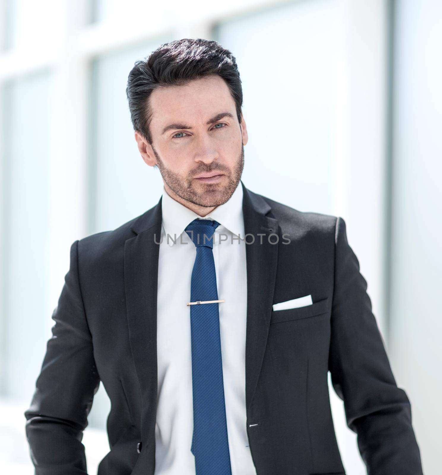 serious businessman standing near an office window.photo with copy space