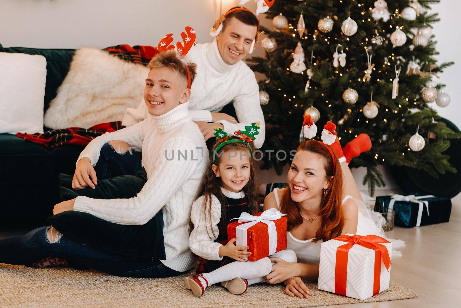 Happy family near the Christmas tree with gifts.