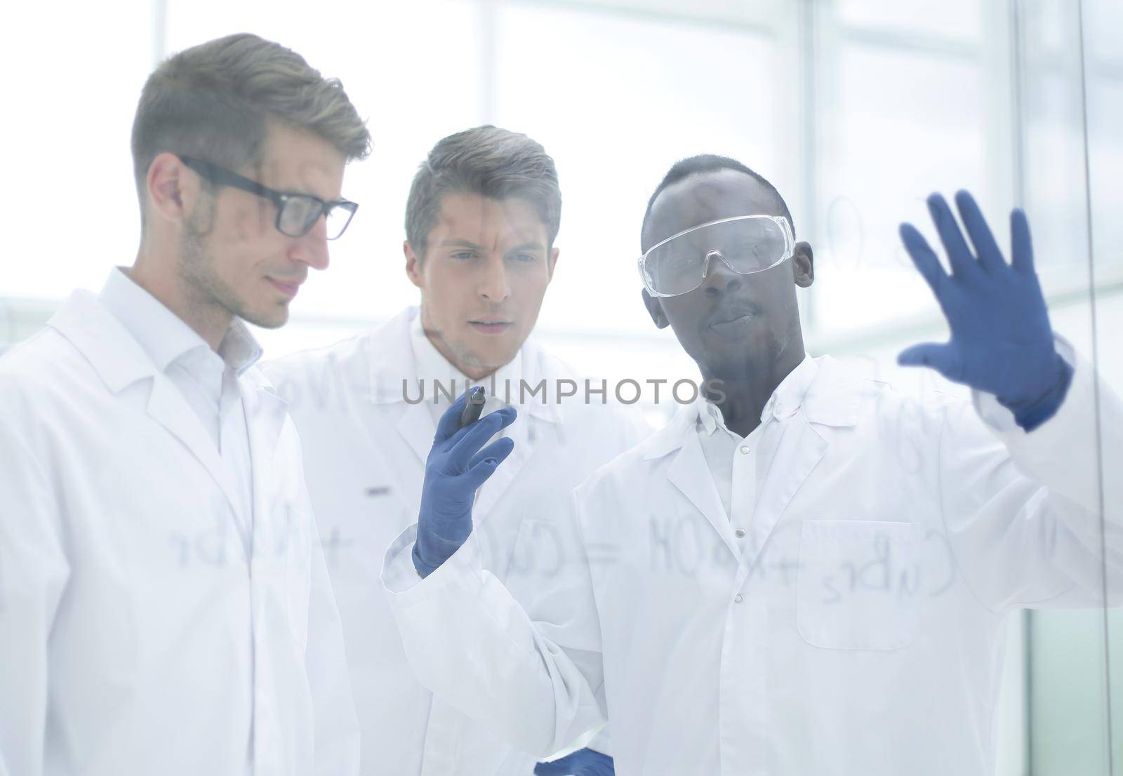 group of scientists consider the records on a glass Board by asdf