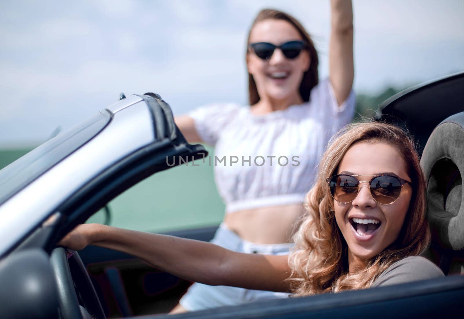 close up.two girlfriends traveling in a convertible car . fashionable lifestyle