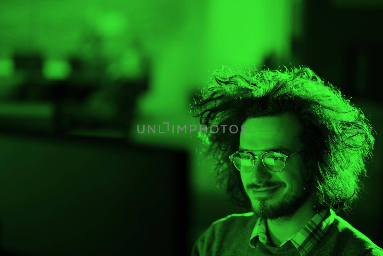 man working on computer in dark office by dotshock