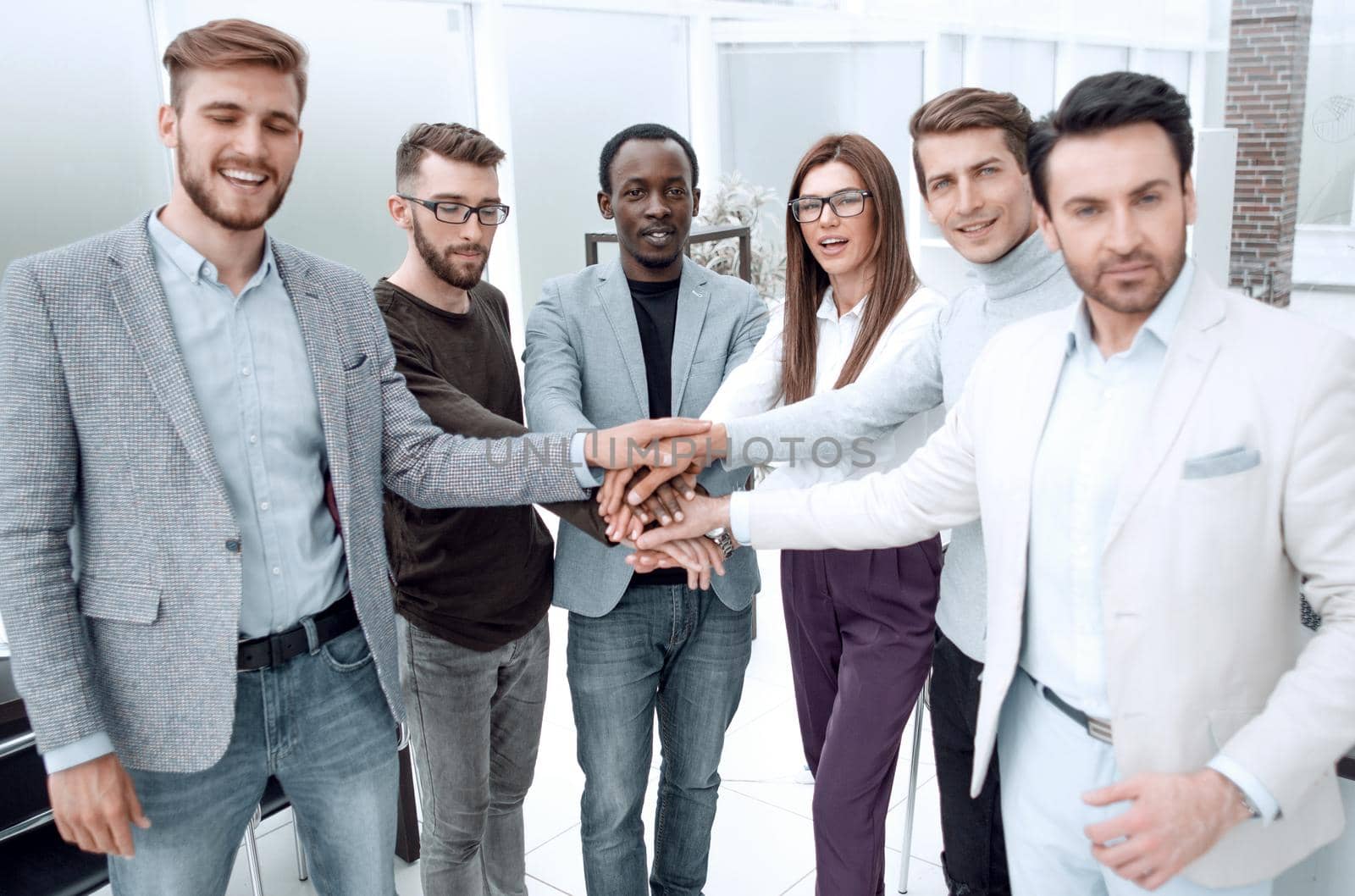 business team doing a bunch of hands at a meeting.the concept of unity