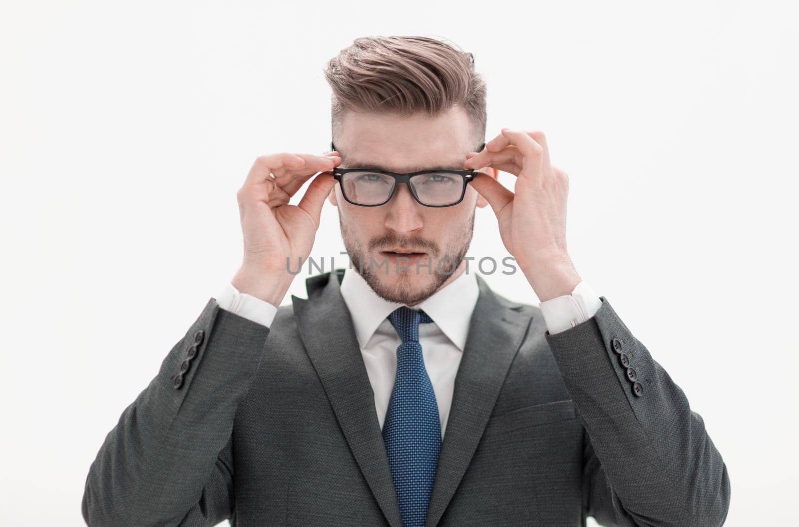 serious businessman adjusting his glasses.isolated on white