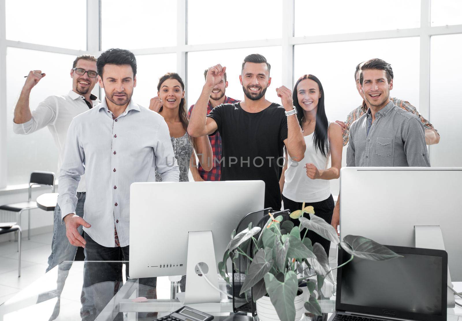 happy business team standing in modern office by asdf