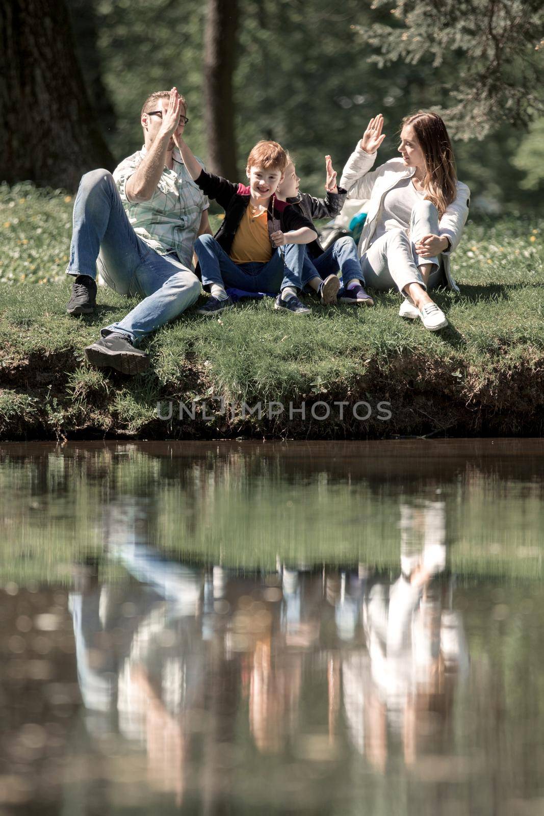 parents and children giving each other a high five on a walk in the Park by asdf