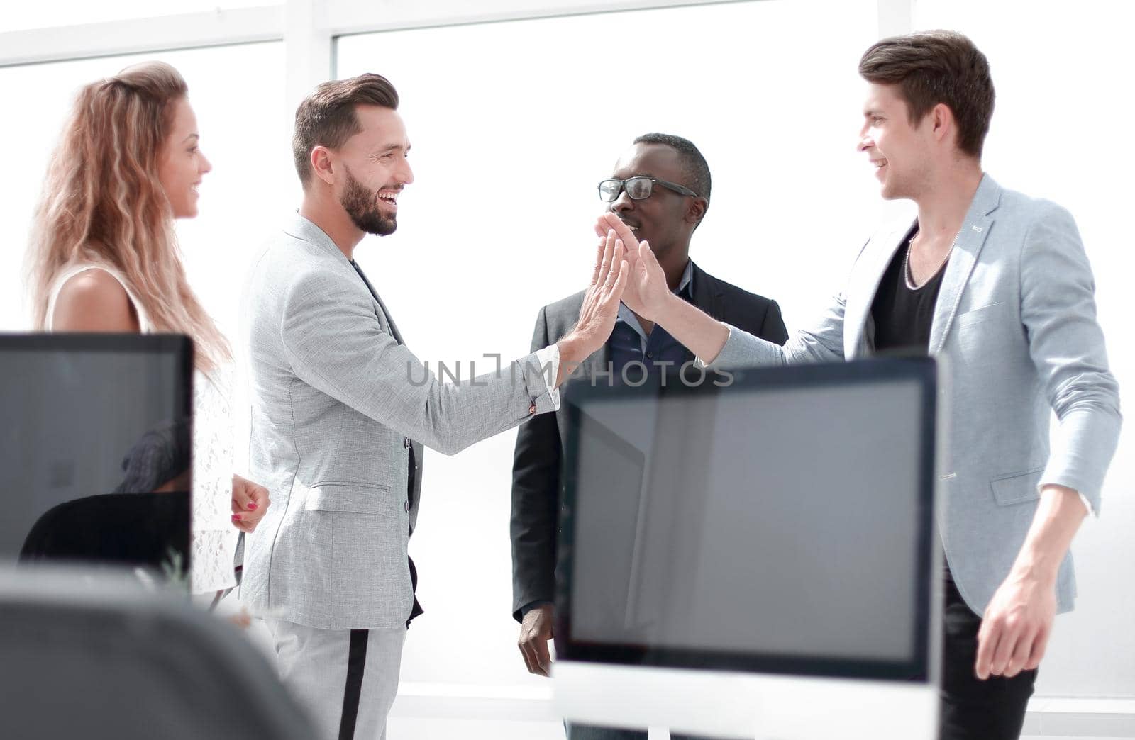 colleagues giving each other a high five while standing in the office.the concept of success