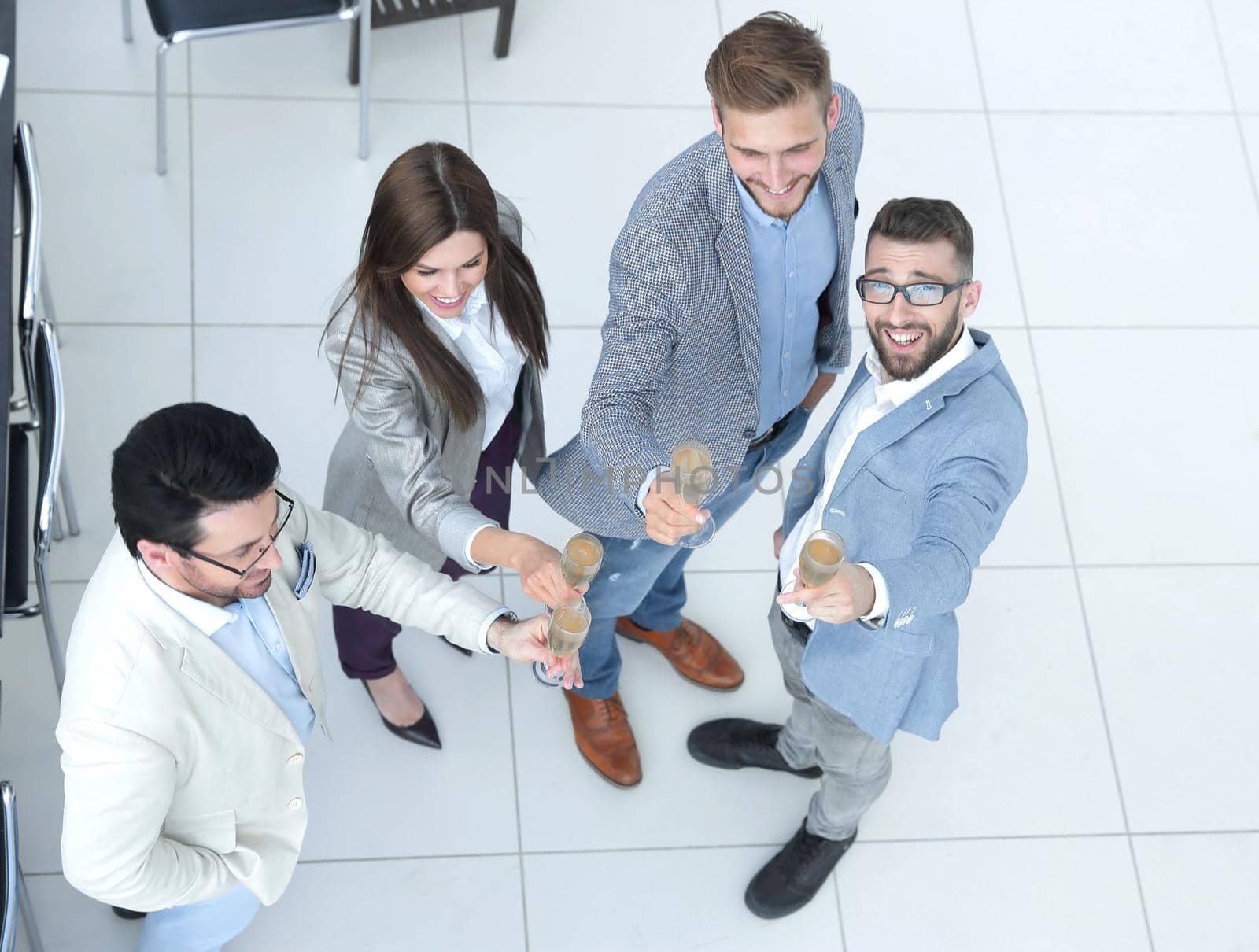 Businesspeople toasting glasses of champagne in office by asdf