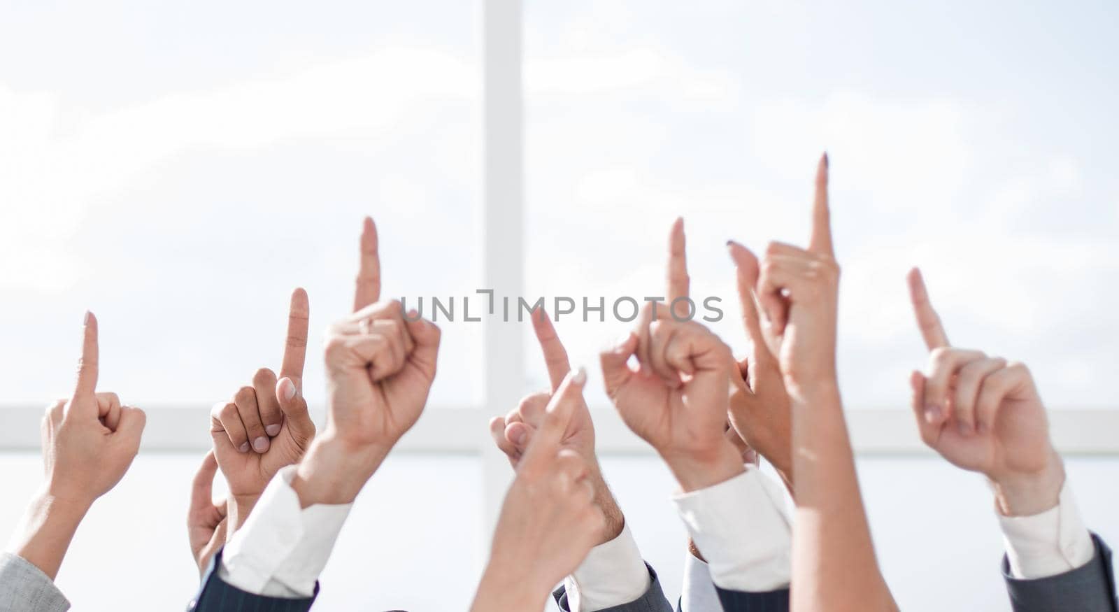 group of young businessmen standing in a circle and pointing up.photo with copy space
