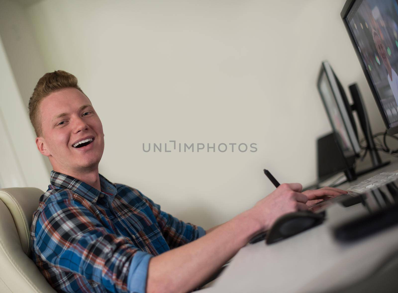 Young graphic designer working on a digital tablet and a computer