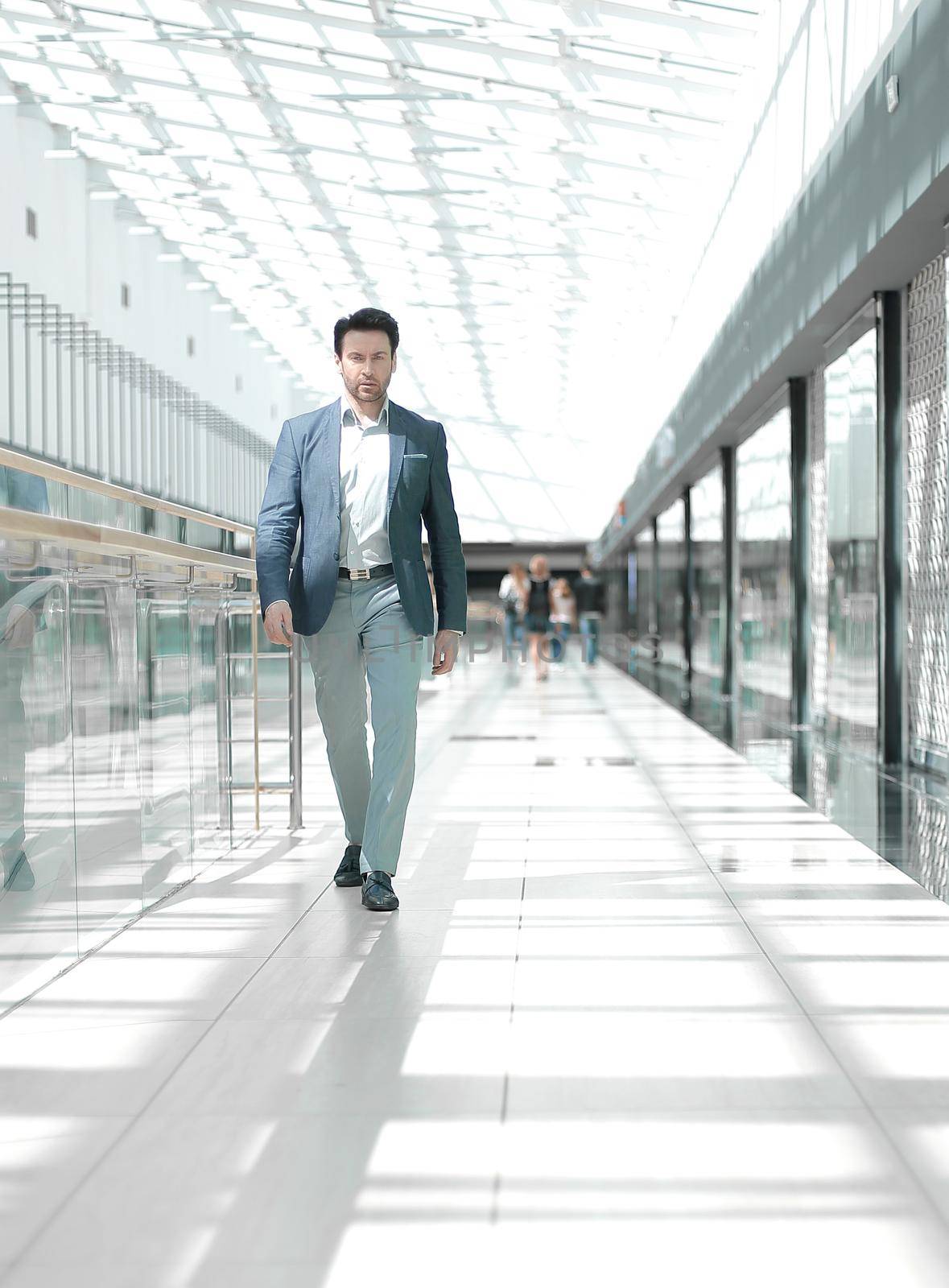 businessman walking in the airport building by asdf