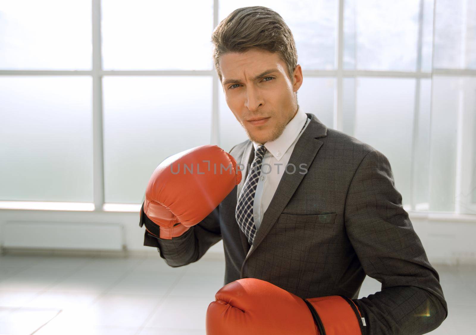 purposeful young businessman in Boxing gloves. concept of competitiveness