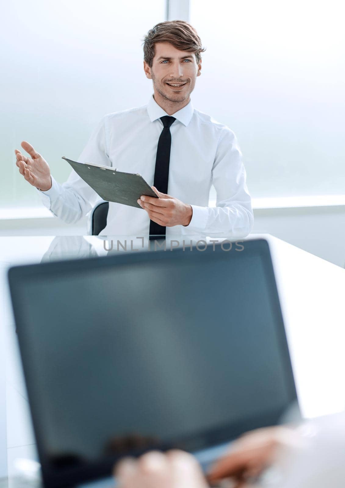 businessman with a clipboard sitting at the negotiating table.business concept