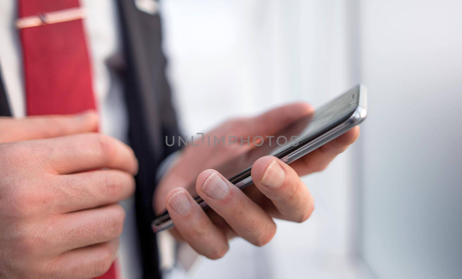 close up.businessman reading text message on smartphone by asdf