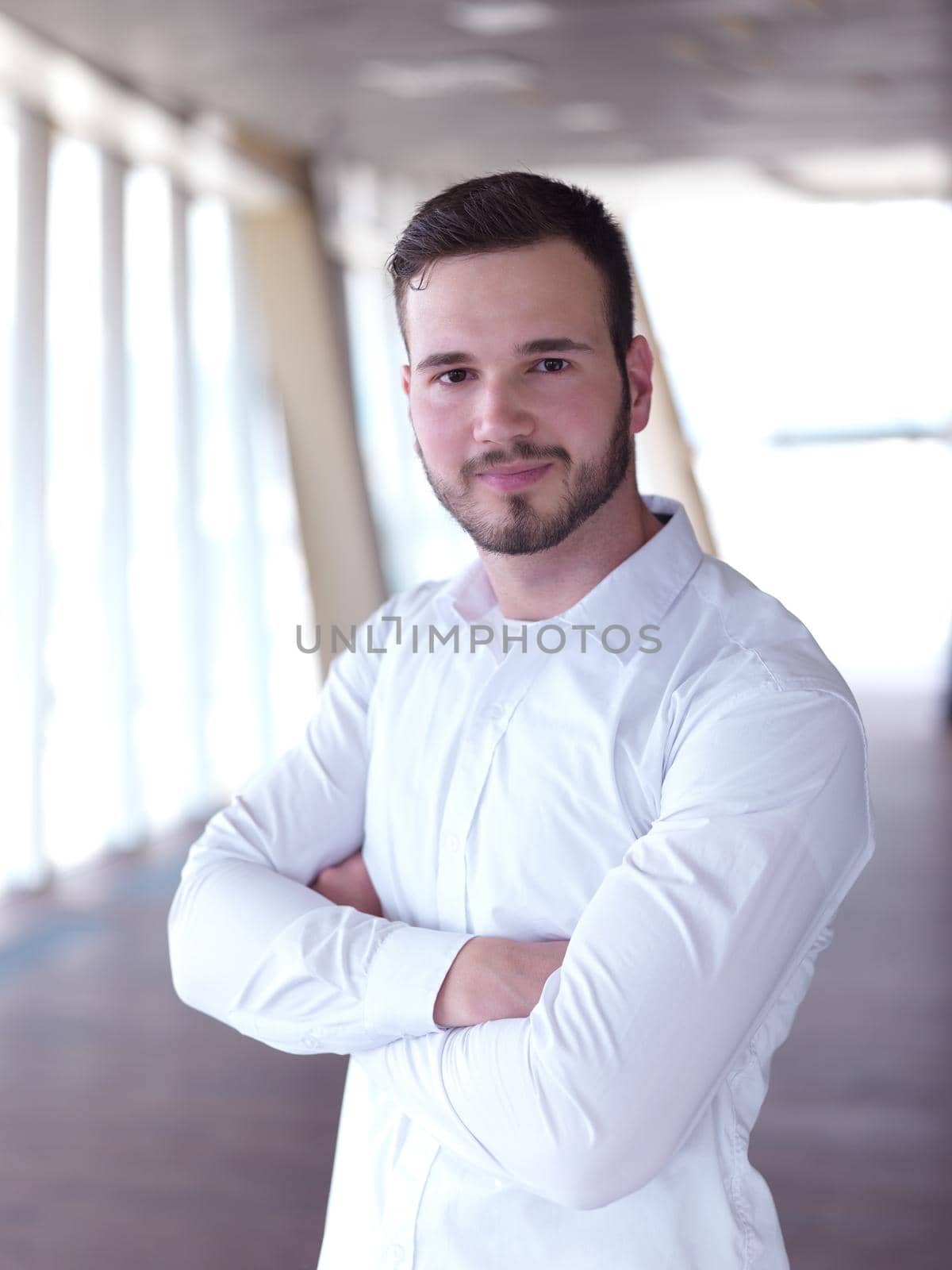 portrait of young handsome hipster business man with beard at modern office space interior