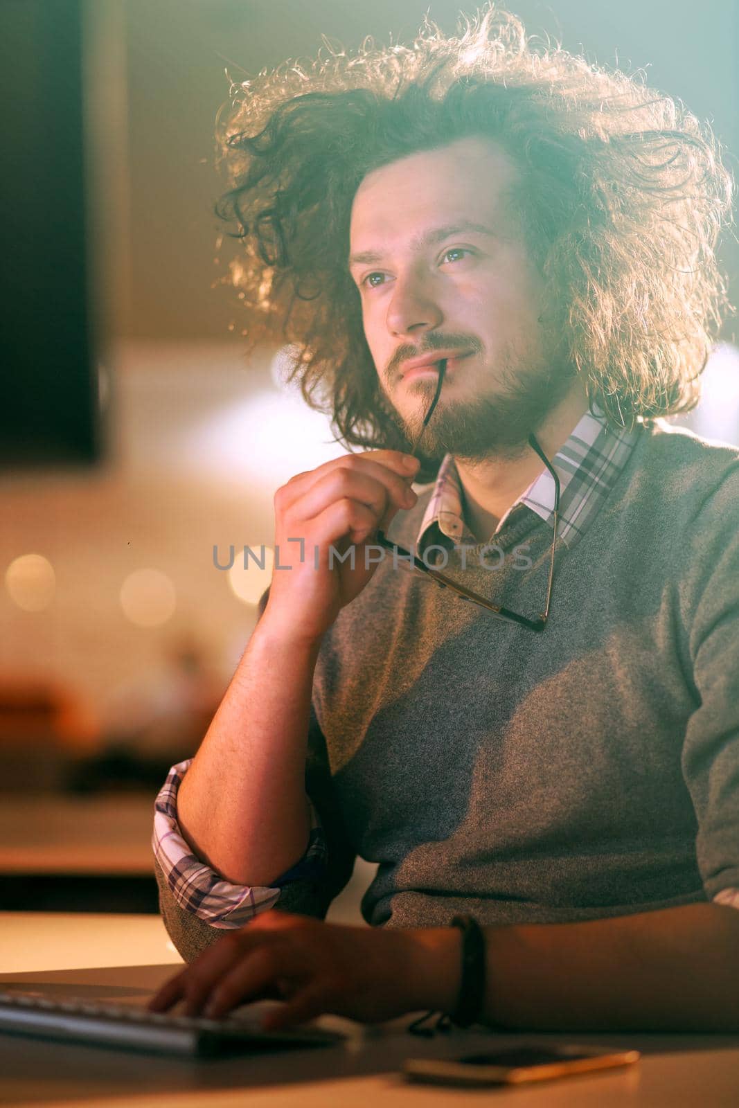 man working on computer in dark office by dotshock