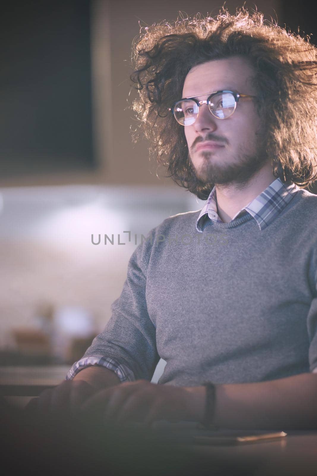 man working on computer in dark office by dotshock