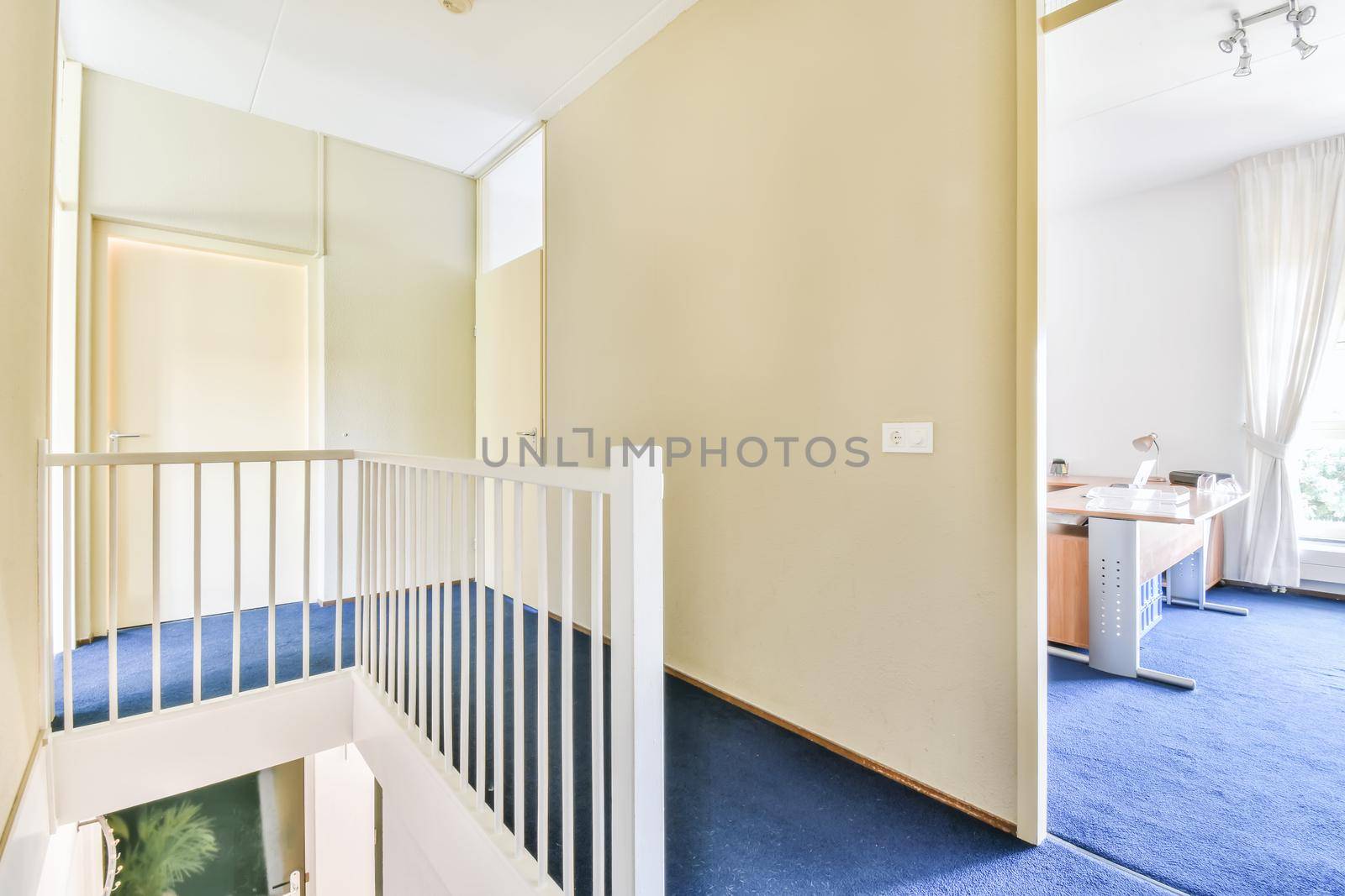 A room with a staircase leading down and a blue floor