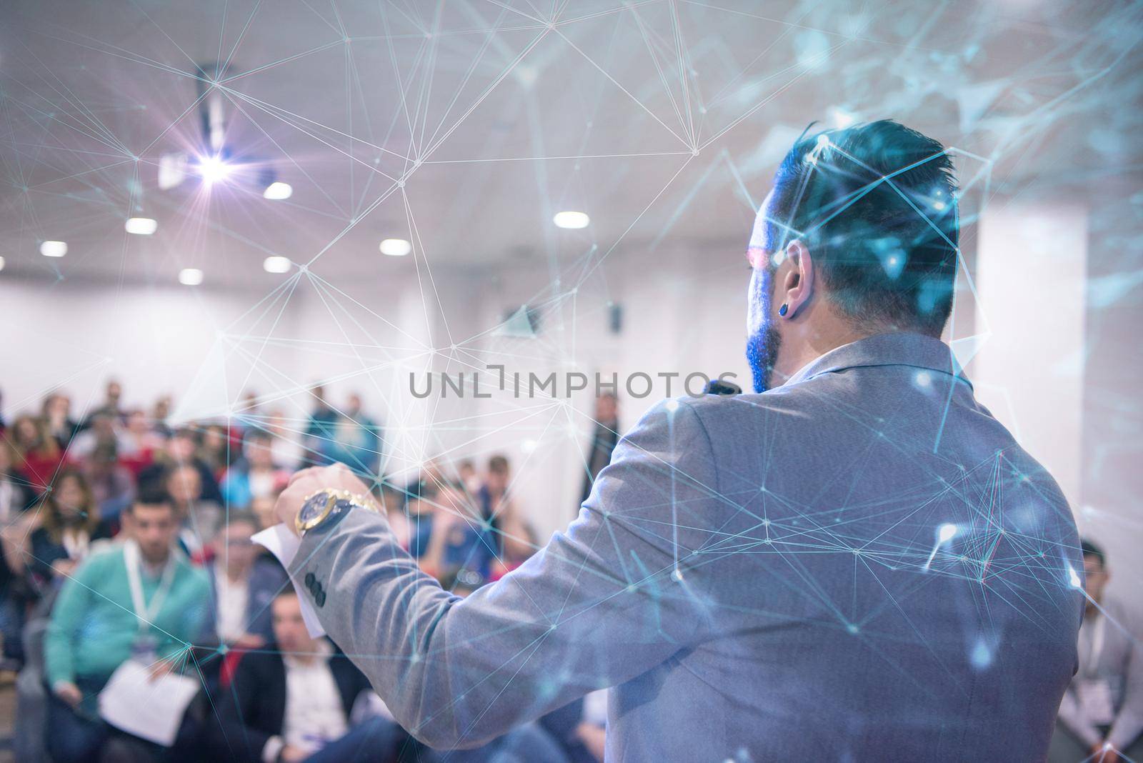 rear view of young successful businessman at business conference room with public giving presentations. Audience at the conference hall. Entrepreneurship club