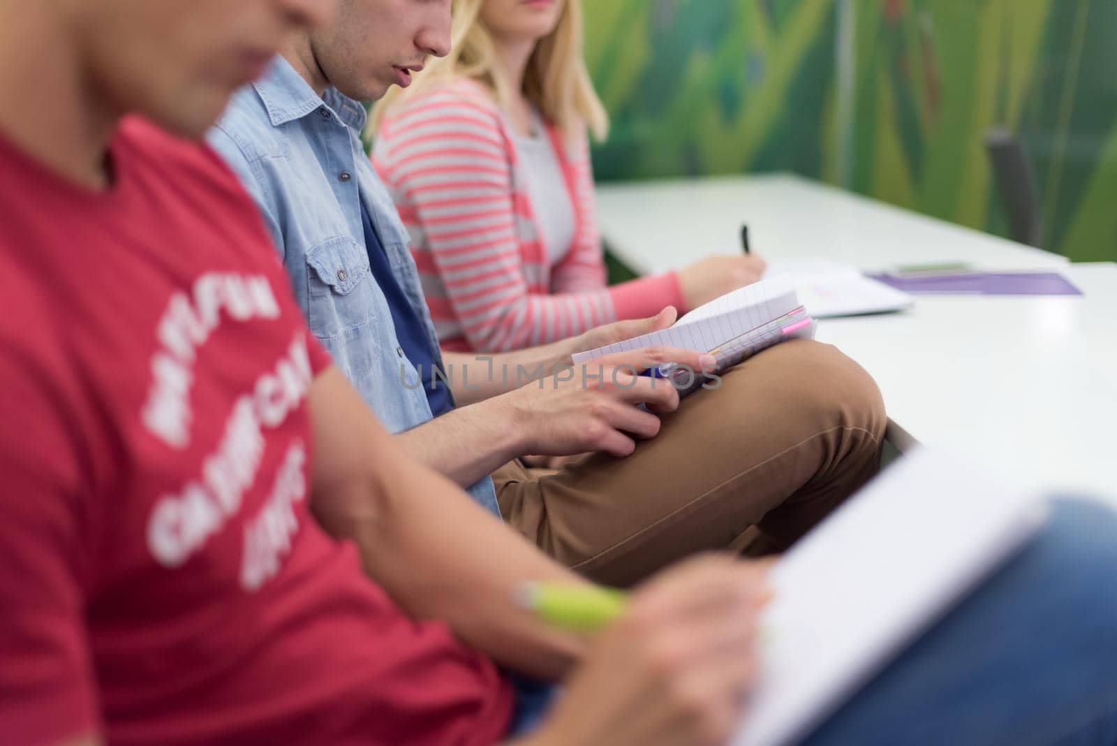 male student taking notes in classroom. business education concept, casual young businessman on seminar training