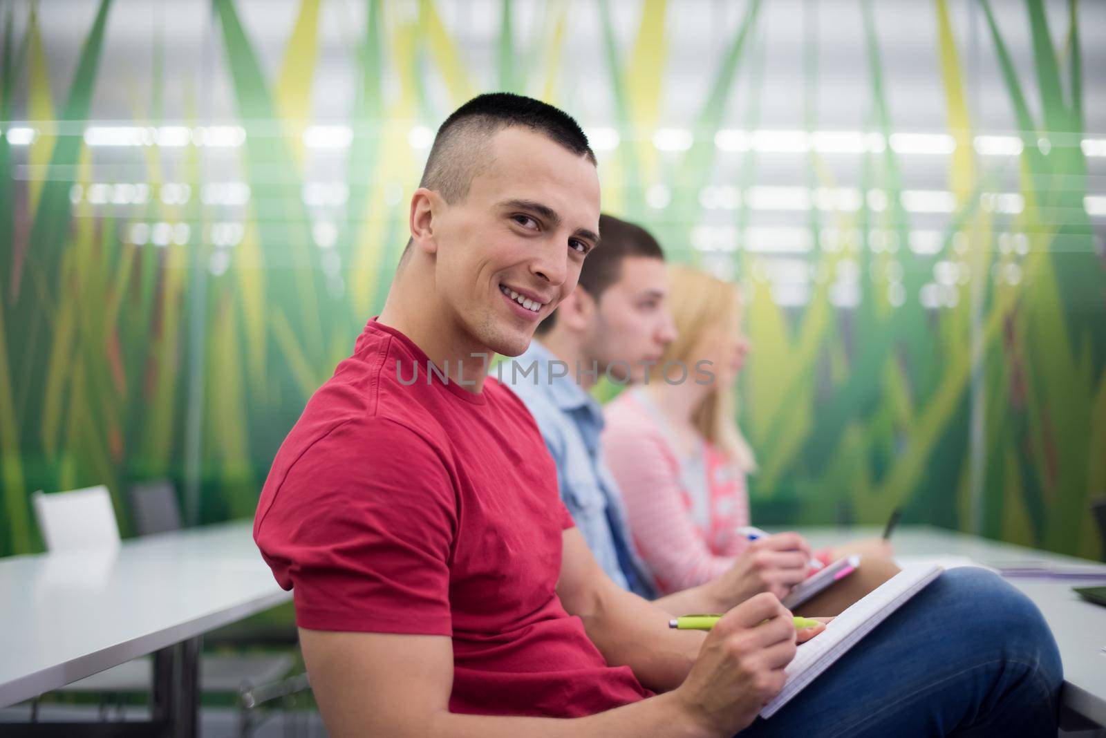 male student taking notes in classroom. business education concept, casual young businessman on seminar training