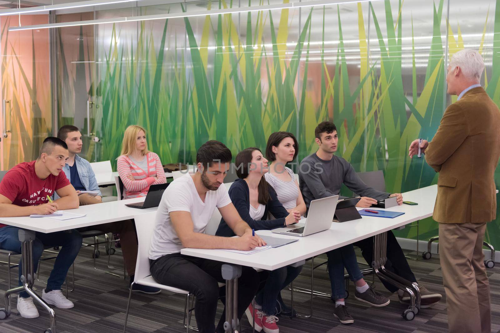 group of students study with professor in modern school classroom