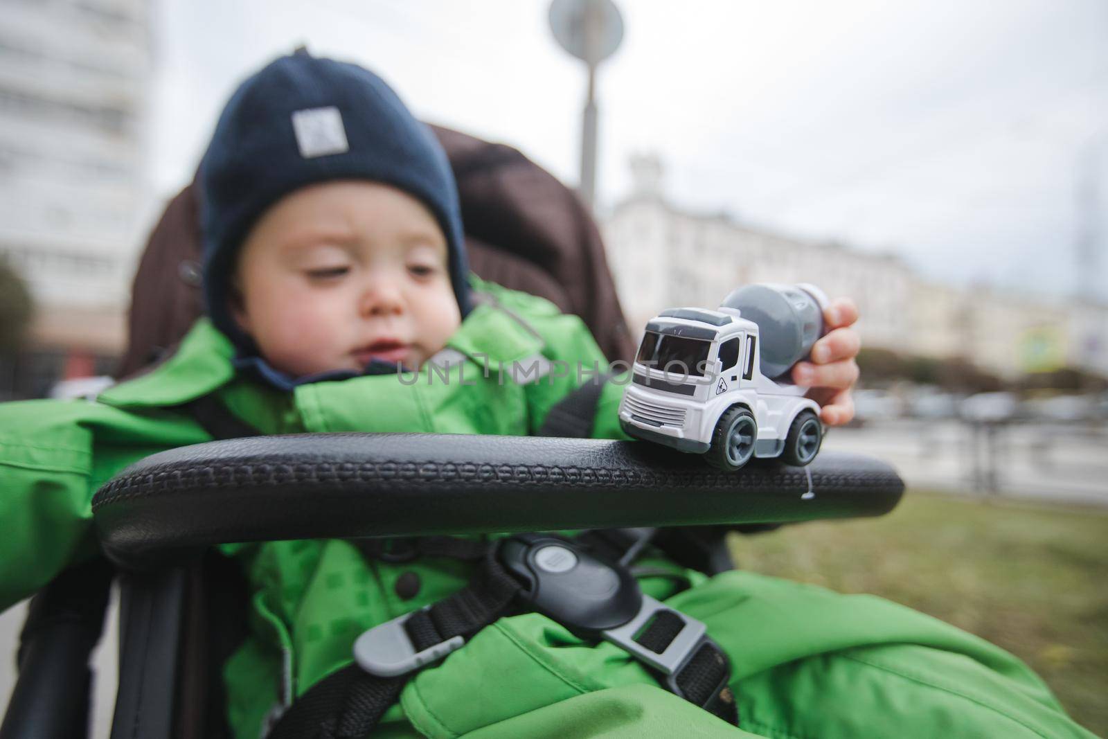 Child in stroller playing with car by Demkat