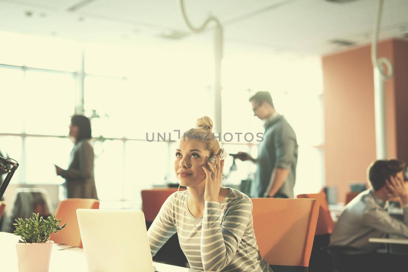 businesswoman using a laptop in startup office by dotshock