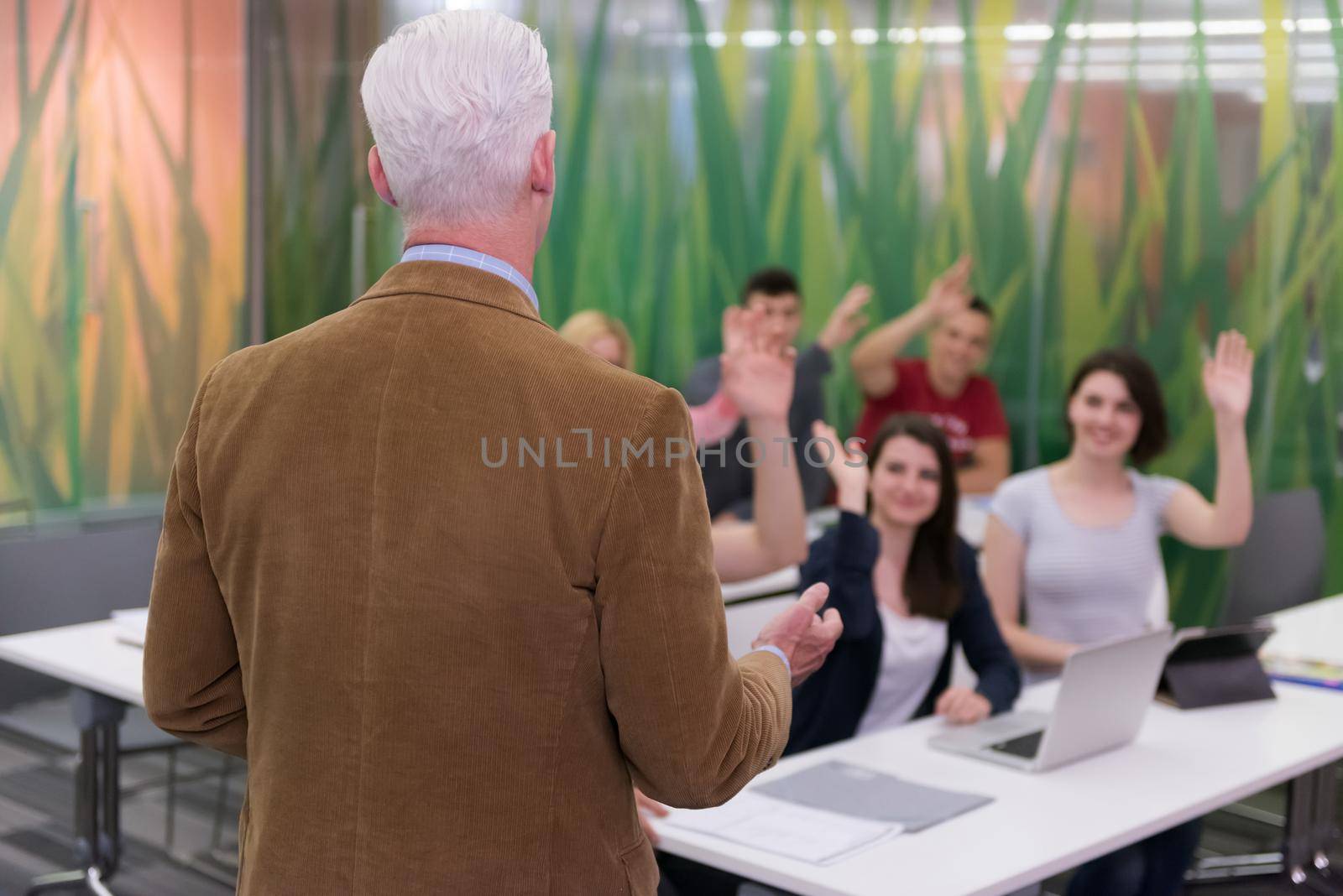 group of students study with professor in modern school classroom