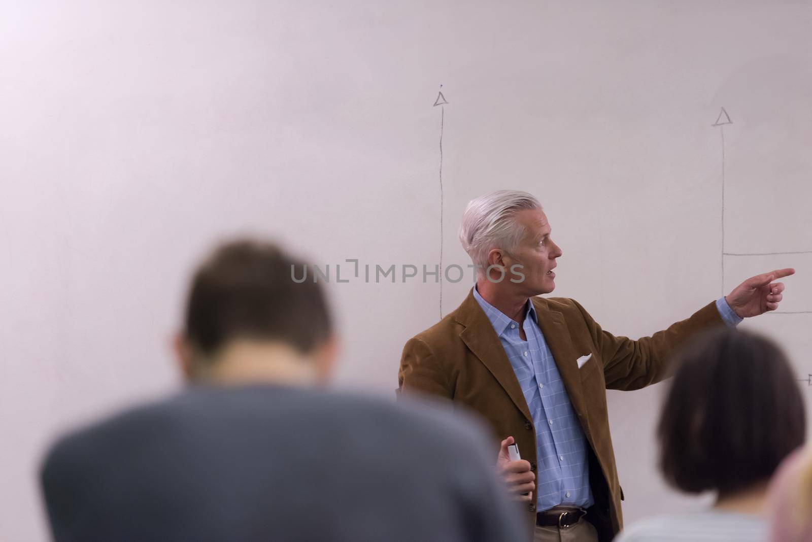 teacher with a group of students in classroom by dotshock